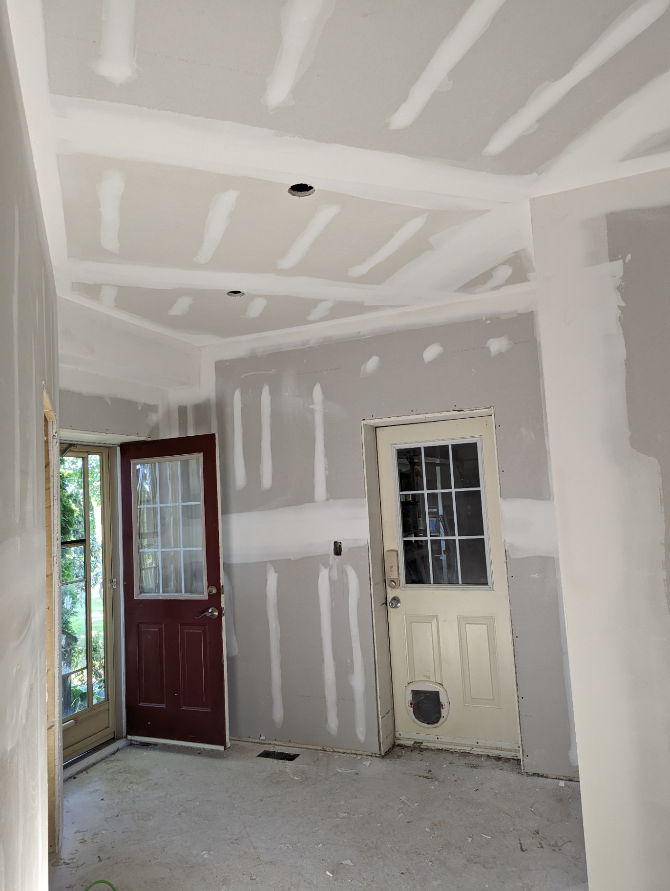 Mudroom with taped ceiling and walls