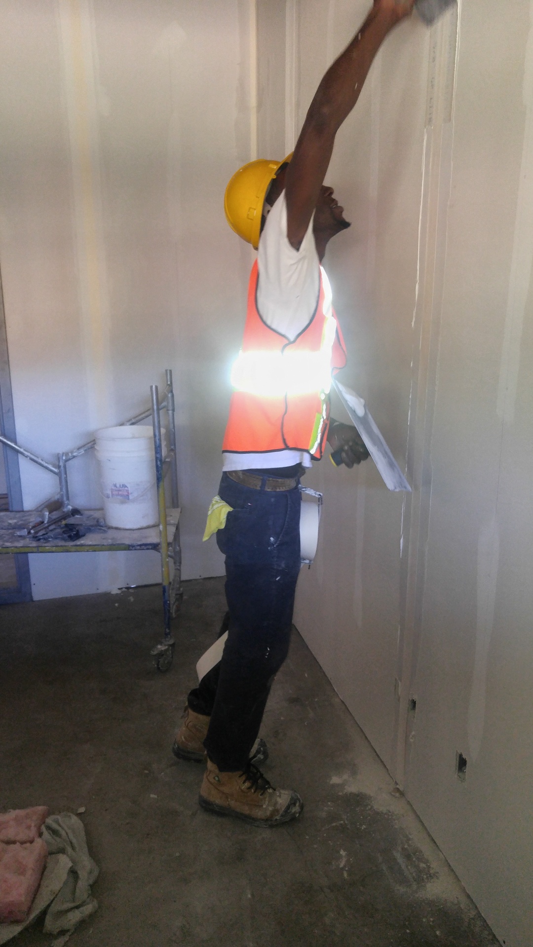 Drywaller skim-coating a fresh wall
