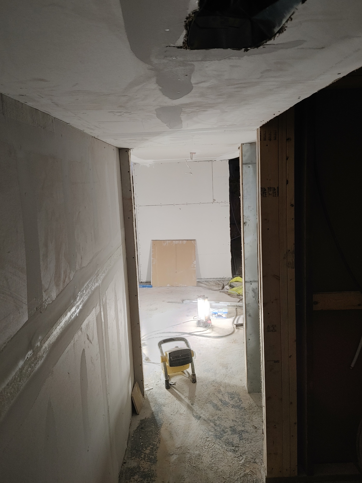 Basement hallway progress with worklights
